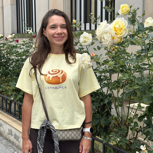 Koszulka Cynamonka kolor Butter zdjęcie na modelce wokół kwiaty.