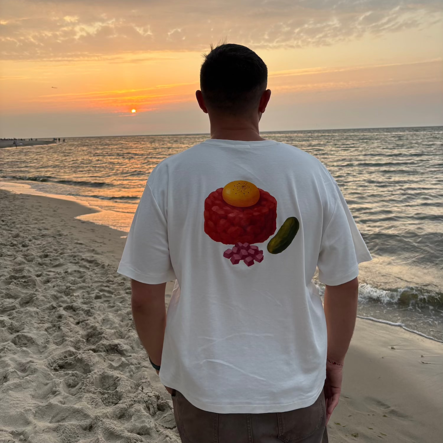 Zdjęcie przedstawia koszulkę TATAR depose na plaży. 