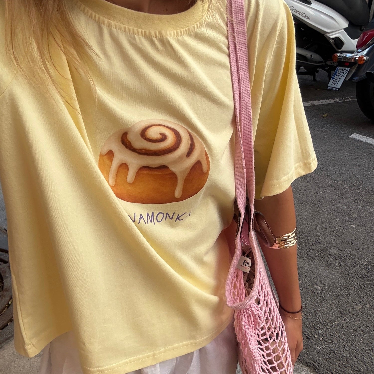 zdjęcie przedstawia koszulkę polskiej marki DEPOSE w letniej stylizacji. Koszulka ma nadruk Cynamonki.